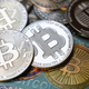 This illustration photo shows a physical banknote and coin imitations of bitcoin.